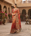 Rust tissue saree with zardozi work, a decorative border and tasselled pallu