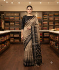 Chiku saree with a contrasting black temple border and patterned black pallu
