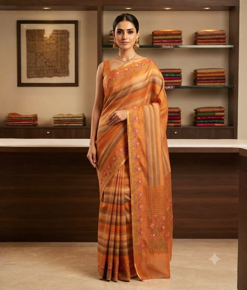 Orange saree with floral thread-work motifs and contrasting striped details